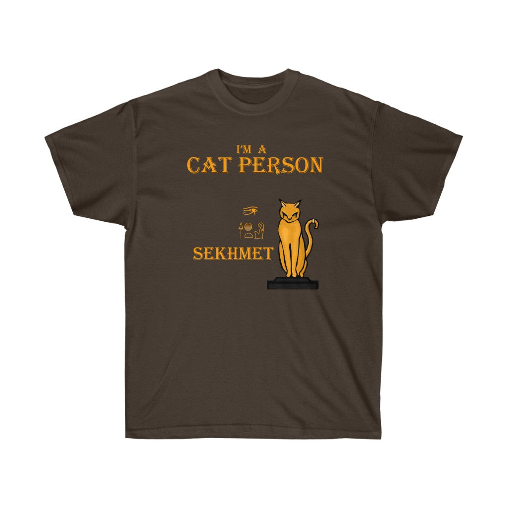 A dark brown shirt. It has a cat based on Sekhmet in the middle. At the top, there is text that reads "I'm a cat person." Below the text is a cat standing on a pedestal. To the left of the cat, there are hieroglyphs and the name "Sekhmet".