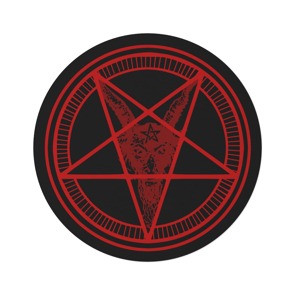 A large baphomet rug sitting on a white background. The rug itself is black with red rings. The inner ring has lines spaced evenly. The center forms a pentacle with a goats head, it's horns at the top points, and its beard flowing down to the bottom. It has a pentagram on its forehead.