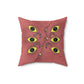 A dark pink throw pillow with specs of black designed to make it look a little dirty. It's stylized to look like a ghoulish mimic. It has 6 eyes, 3 on each side, multiple legs akin to a hermit crab (Segmented with hairs on them, curving at each segment), and a curved "mouth" going through the center with multiple teeth popping out.