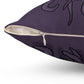 A purple throw pillow. The zipper that removes the cover is zoomed in on. There are traces of tentacle prints above and below the zipper.