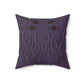 A purple throw pillow with a stylized rendition of cthulu's face on it. It prominently features four eyes at the top and his tentacles below them.