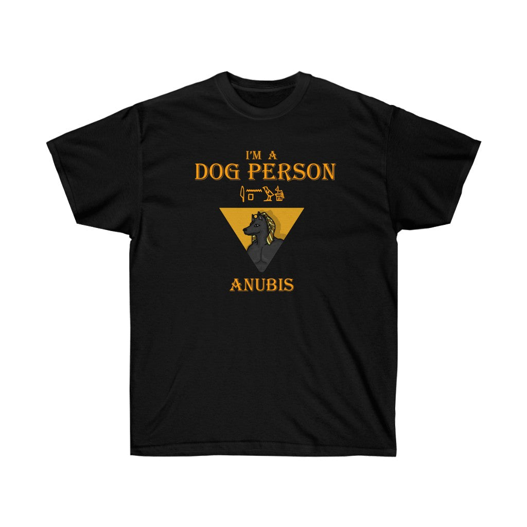 A black shirt. It has a graphic of Anubis centered in a triangle in the middle. At the top, golden text reads "I'm a dog person." At the bottom, golden text reads "Anubis." Above the graphic is Anubis in hieroglyphics.