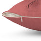 A dark pink throw pillow. The zipper that removes the cover is zoomed in on. 