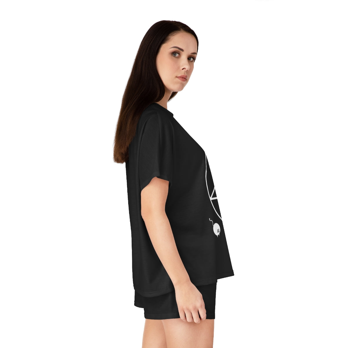 A side view of a woman with long black hair wear a black pajama shirt and black pajama shorts. You can see part of a pentacle and a chibi mouse on the shirt.